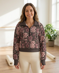 Woman wearing the Midnight Peony half-zip fleece pullover in a sunlit yoga studio