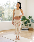 Woman wearing the Sunrise Arches high-waisted yoga leggings on a yoga mat