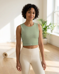 Woman wearing the Breath Lines Sage yoga crop tank in a sunlit yoga studio